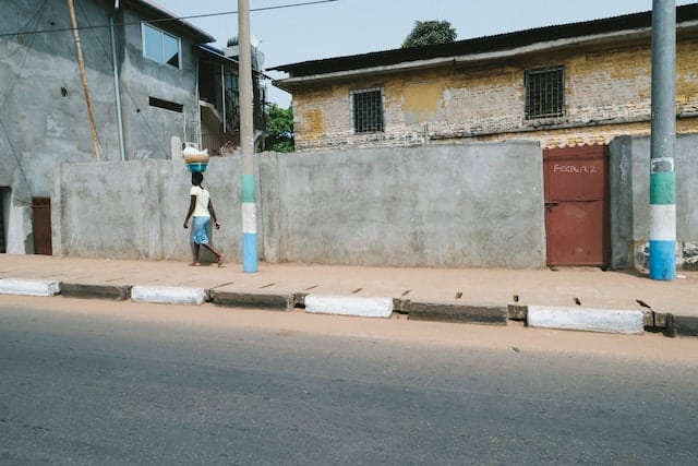 Woman walks in Sierra Leone, dressed in colors of their flag.