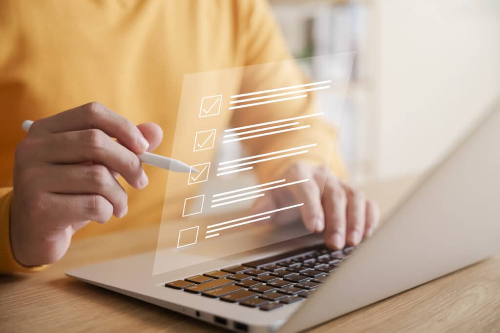 Man in yellow short typing on laptop.